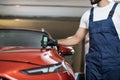 Closeup view of male hand, using film coating thickness gauge device to check car paint. Royalty Free Stock Photo