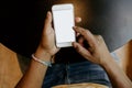 Closeup view of male hands touching mobile phone.African man using smartphone while sitting at the wooden table.Empty Royalty Free Stock Photo