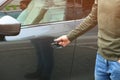 Closeup view of man opening car door with key Royalty Free Stock Photo