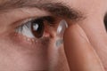 Closeup view of man putting contact lens in his eye Royalty Free Stock Photo