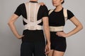 Closeup view of man and woman with orthopedic corsets on grey background Royalty Free Stock Photo