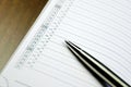 Closeup view of a metal pen lying on the diary with a timetable Royalty Free Stock Photo