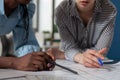 Closeup view of mixed race architects holding pencil and pen over blueprints Royalty Free Stock Photo