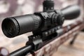Closeup view of modern powerful sniper rifle with telescopic sight on blurred background Royalty Free Stock Photo