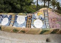 Closeup view of a mosaic seating area adorned with multi-colored tiles in Park Guell in Barcelona, Spain.