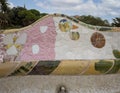 Closeup view of a mosaic seating area adorned with multi-colored tiles in Park Guell in Barcelona, Spain.