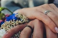 Closeup view of newlyweds hands holding colorful wedding bouquet. Bride and groom wearing wedding rings. Outdoor Royalty Free Stock Photo