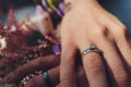 Closeup view of newlyweds hands holding colorful wedding bouquet. Bride and groom wearing wedding rings. Outdoor Royalty Free Stock Photo