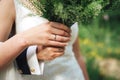 Closeup view of newlyweds hands holding colorful wedding bouquet. Bride and groom wearing wedding rings. Outdoor Royalty Free Stock Photo