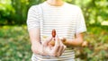 Closeup view of one date holded by unrecognizable white man in sriped tshirt with some other dates in a bowl behind. selective