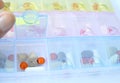 Closeup view of open plastic pill organizer with drugs inside for a weekly dosage Royalty Free Stock Photo