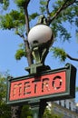 Closeup view of Paris metro sign by day, tree and blue sky in background