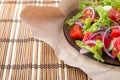 Closeup view on a plate with fresh salad of raw tomatoes, lettuce and onion Royalty Free Stock Photo