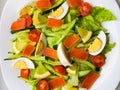 Closeup view of plate full of fresh green salad with mint leaves, yellow corn, tomato, tuna fish served with juicy lemon sauce. Royalty Free Stock Photo