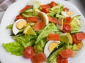 Closeup view of plate full of fresh green salad with mint leaves, yellow corn, tomato, tuna fish served with juicy lemon sauce. Royalty Free Stock Photo