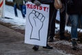 Closeup view of a protester holding a banner with a writing of resist