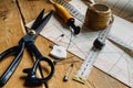 closeup view of retro sewing tools, scissors, chalk, measuring tape lie on tailors& x27; diagrams and wooden table Royalty Free Stock Photo