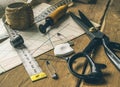 closeup view of retro sewing tools, scissors, chalk, measuring tape lie on tailors& x27; diagrams and wooden table Royalty Free Stock Photo