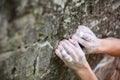 Rock climber`s hands gripping hold on cliff Royalty Free Stock Photo