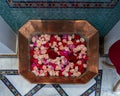 Closeup view of roses and petals floating in a copper basin inside La Maison Arabe in Marrakesh, Morroco.