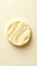 Closeup view of a round creamy texture with smooth swirls against a light backdrop