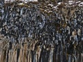Closeup view of slope with volcanic basalt columns with icicles near near Svartifoss waterfall in Skaftafell, Iceland, in winter.