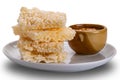 Closeup view stack of crispy rice crackers with peanut sauce in brown ceramic cup