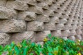 Closeup view of a stacked block wall and green foliage underneath