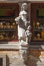 Closeup view of the statue of a lady with a boy on the facade of a store in a historical building