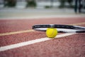 Closeup view on tennis ball and racket racquet lying on acrylic tennis hard court surface with empty blank copy space Royalty Free Stock Photo