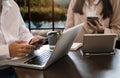 Closeup view of three young coworkers working on mobile laptop computer at office.Young woman holding tablet Royalty Free Stock Photo