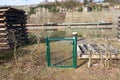 Closeup view of a tiny metallic green fence near the water on a sunny day Royalty Free Stock Photo