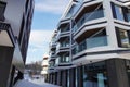 Closeup view to new modern apartments at Kalamaja. Empty bus stop on the back. Winter time with white snow. Royalty Free Stock Photo