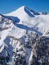 Closeup view to the rocky mountain peak covered with snow