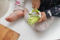 Toddler girl peeling cucumber