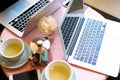 Closeup view of two opened laptop screen, space for design layout. Meeting in co-working or cafe, daylight, cup tea and flowers on