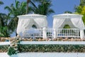 Closeup view of two white cozy gazebos in tropical garden on sunny gorgeous day