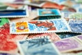 Closeup view on a variety of multi-colored postage stamps from different countries and years. Selective focus
