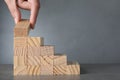 View of woman building steps with wooden blocks on grey table, space for text. Career ladder Royalty Free Stock Photo