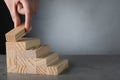 Closeup view of woman building steps with blocks on grey table, space for text. Career ladder Royalty Free Stock Photo