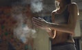 Woman climber is chalking hands with white chalk powder before climb in indoor climbing gym. woman getting ready to