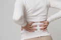 Closeup view of woman having back pain in her back after work, isolated. scoliosis, osteoporosis Royalty Free Stock Photo