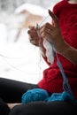 Woman knitting with cotton thread by the window