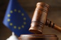 Closeup view of wooden judge`s gavel and European Union flag on blurred background, closeup. Space for text Royalty Free Stock Photo