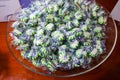 A closeup view of wrapped starlight mint hard candies in a clear glass or plastic bowl on a wooden table Royalty Free Stock Photo