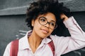 Closeup view of young african american student female wearing eyeglasses getting ready to go to college posin on street. Beautiful Royalty Free Stock Photo