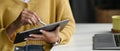 Closeup view of young woman holding digital tablet on hand and using electronic pen at office. Royalty Free Stock Photo