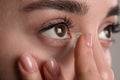 Closeup view of young woman putting contact lens in her eye Royalty Free Stock Photo