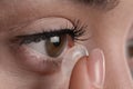 Closeup view of young woman putting contact lens in her eye Royalty Free Stock Photo