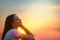 Closeup view of young woman sitting on a pier and watching the sunset Royalty Free Stock Photo